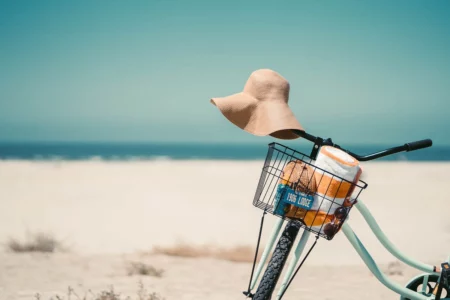 A perfect beach day with a bike ride and a sunhat, as captured in this image, is a great way to practice self care. Plan days like this in your weekly planner.