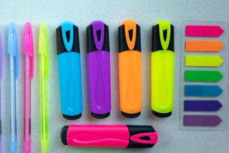 An image of monthly planning tools including highlighters, colored pens and sticky notes.