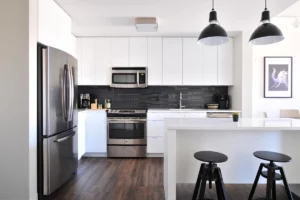 A modern kitchen with stools and energy-efficient appliances - using energy-efficient appliances to save electricity as part of tips on 'How to Save Money on My Electric Bill'.