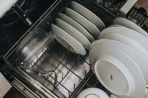 Dishes in a dishwasher - a reminder to use appliances wisely as part of tips on 'How to Save Money on My Electric Bill'.