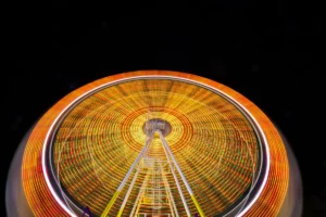 Fetch Rewards explained: Spin the wheel and earn points with Fetch Rewards. Redeem them for fun activities like Ferris wheel rides, or use them to save on everyday purchases. Image of a Ferris wheel ride at a fair.